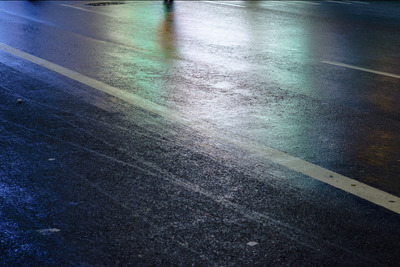 a person walking down a street at night with an umbrella