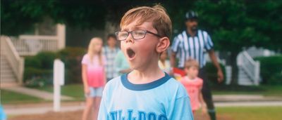 a young boy in a blue shirt is singing