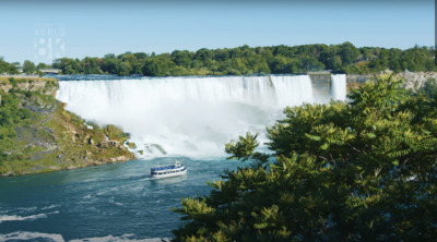 a boat is in the water near a waterfall