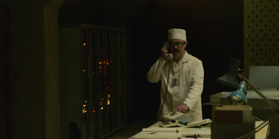 a man in a chef's outfit talking on a cell phone