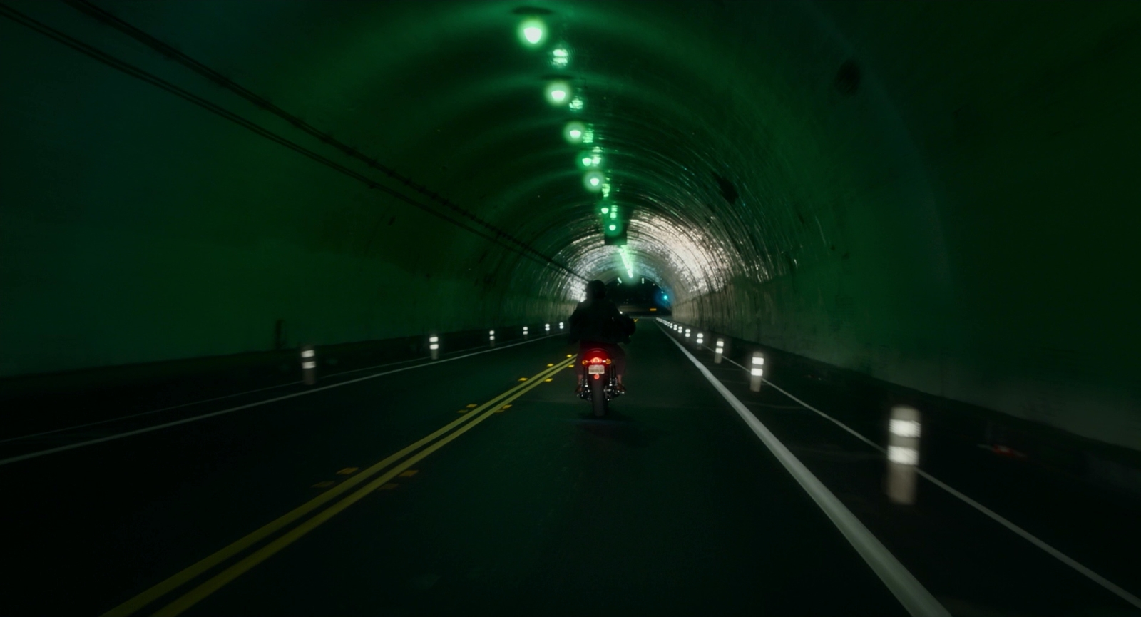 a person riding a motorcycle in a tunnel