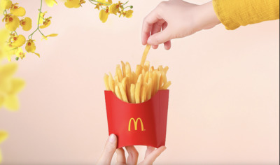 a person holding a box of french fries