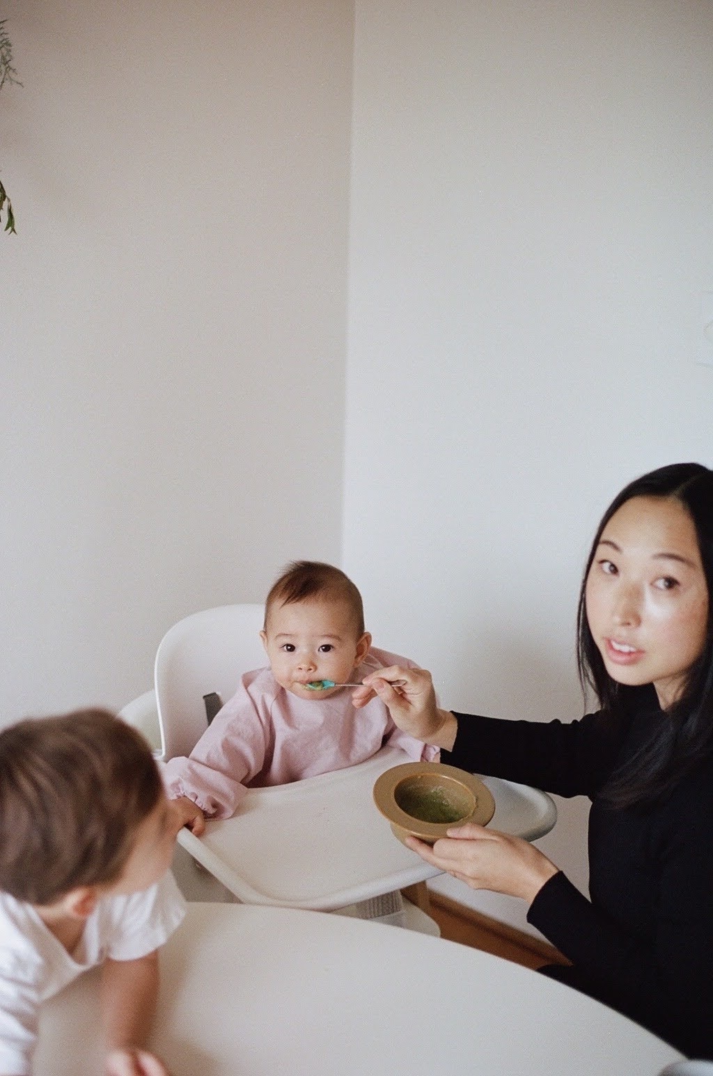 a woman feeding a baby with a spoon