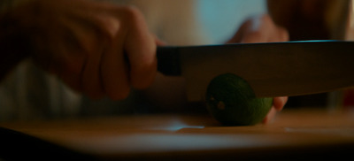 a person cutting a green apple with a knife