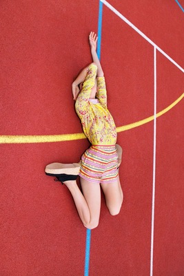 a woman in a yellow dress is on a red floor