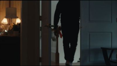 a man walking into a room with a door open