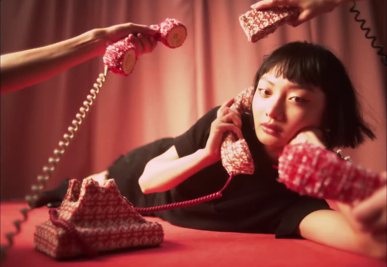 a woman laying on a bed while talking on a phone