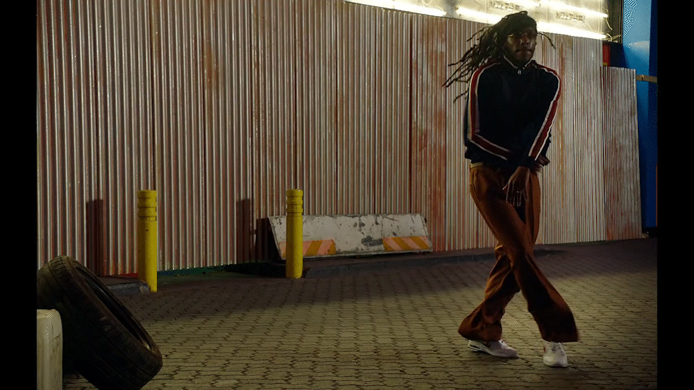 a woman with dreadlocks walking down a street