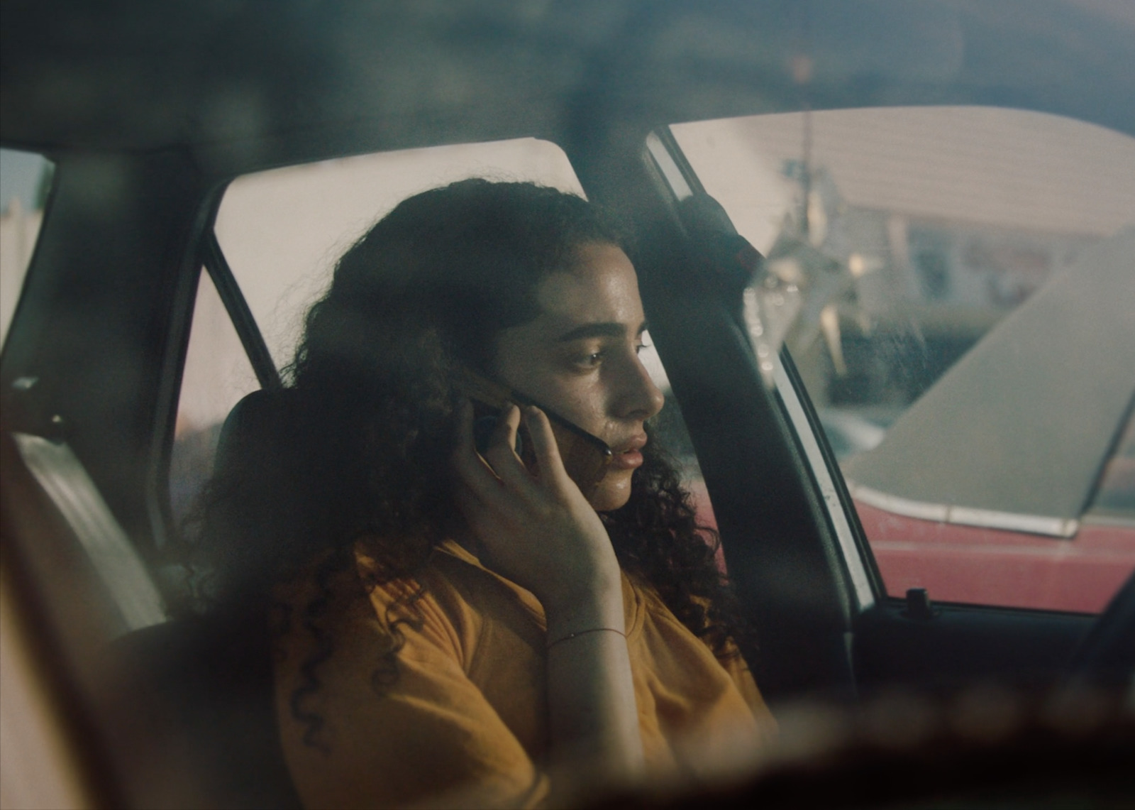 a woman sitting in a car talking on a cell phone