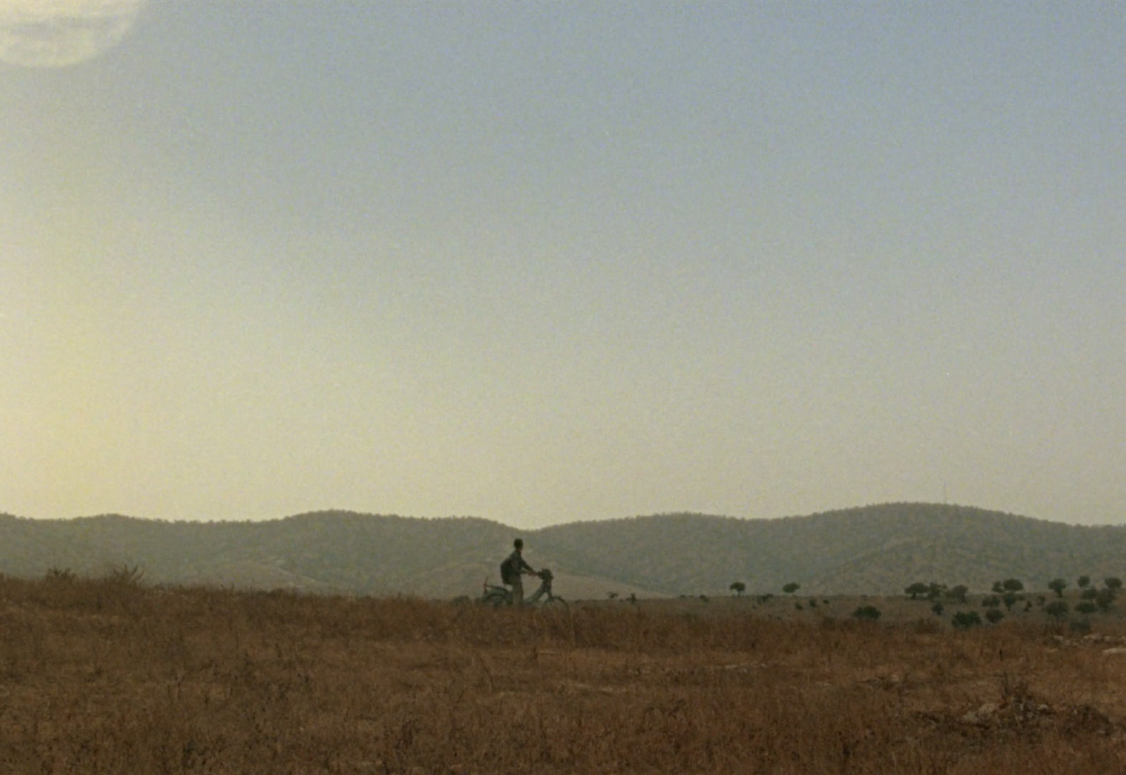 a man riding a horse through a dry grass field