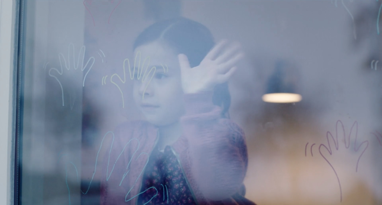 a young girl standing in front of a window