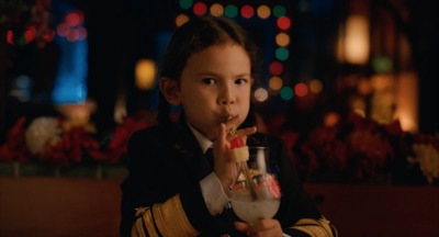 a little girl eating food and drinking a drink