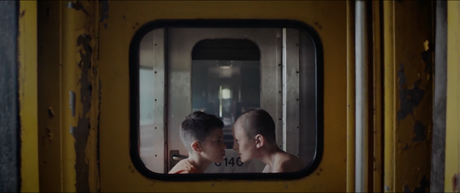 a man and a woman are looking out of a train window