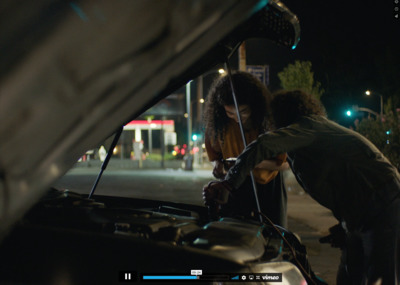 two people working on a car at night