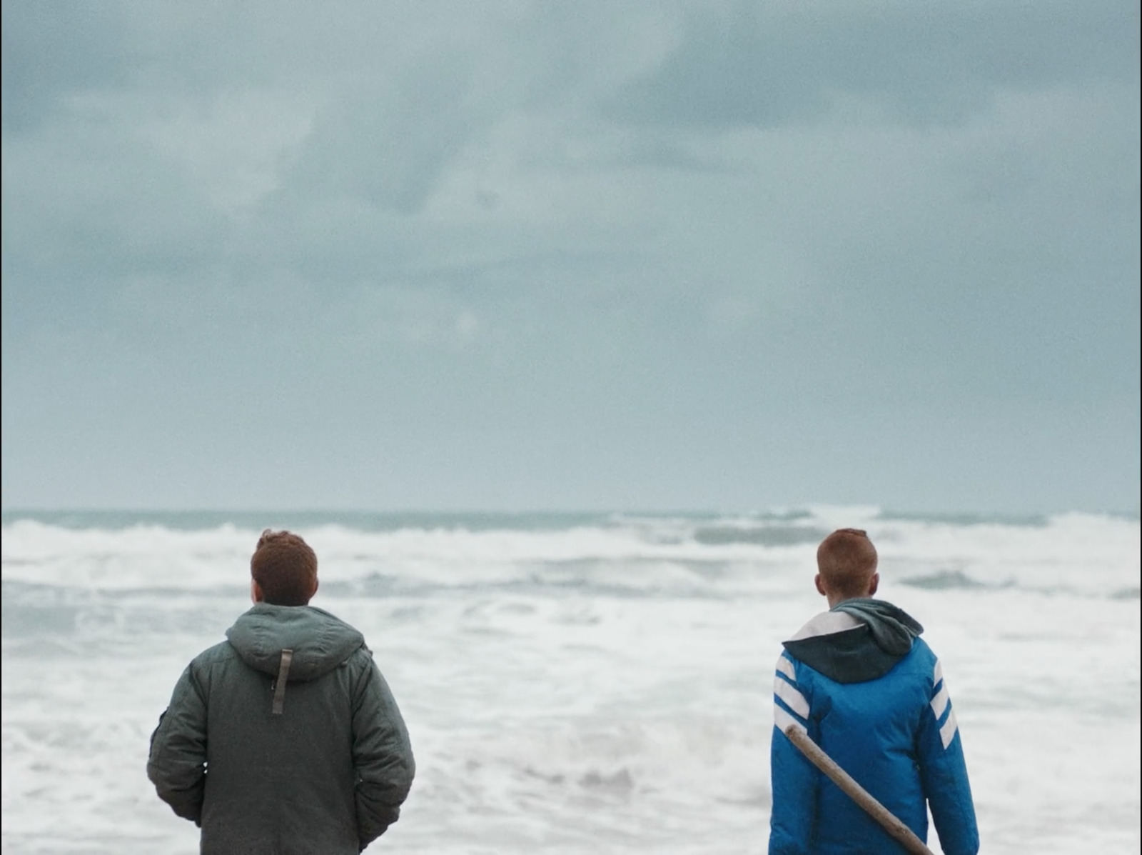 a couple of people standing on top of a beach