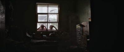 a woman sitting in a chair looking out of a window