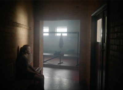 a woman sitting on a bench in a dark room