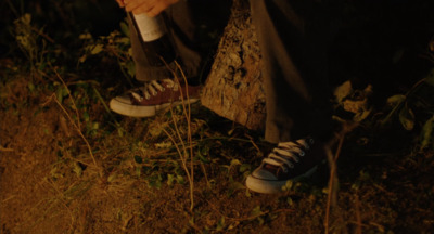 a person standing in the grass with their shoes on