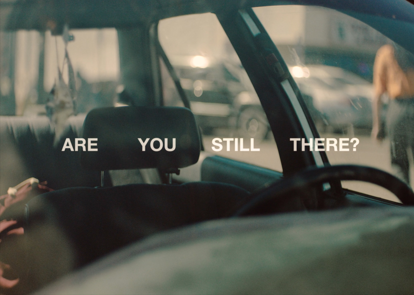 a woman sitting in a car with the words are you still there?