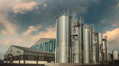 a factory building with a cloudy sky in the background