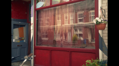 a red door with a reflection of a building in it