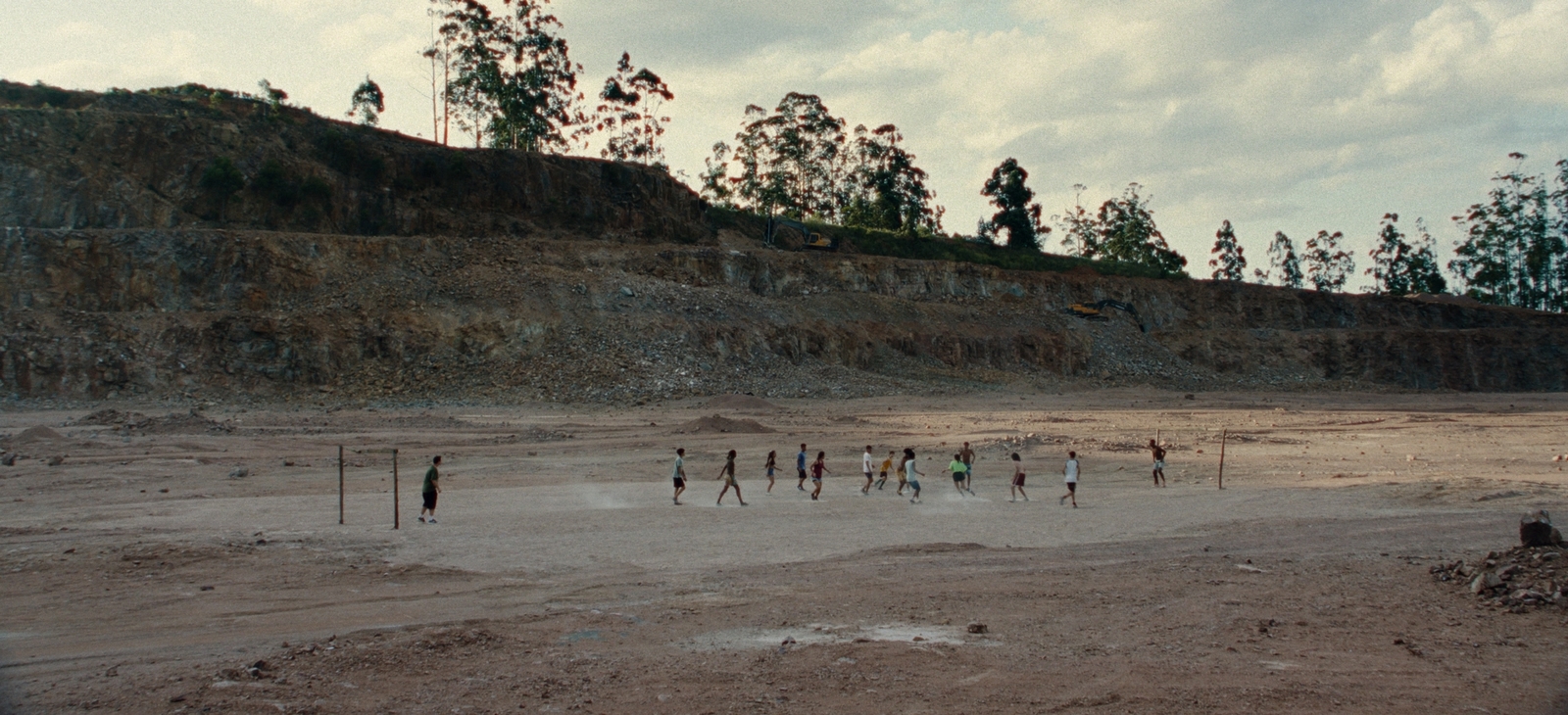 a group of people walking across a dirt field