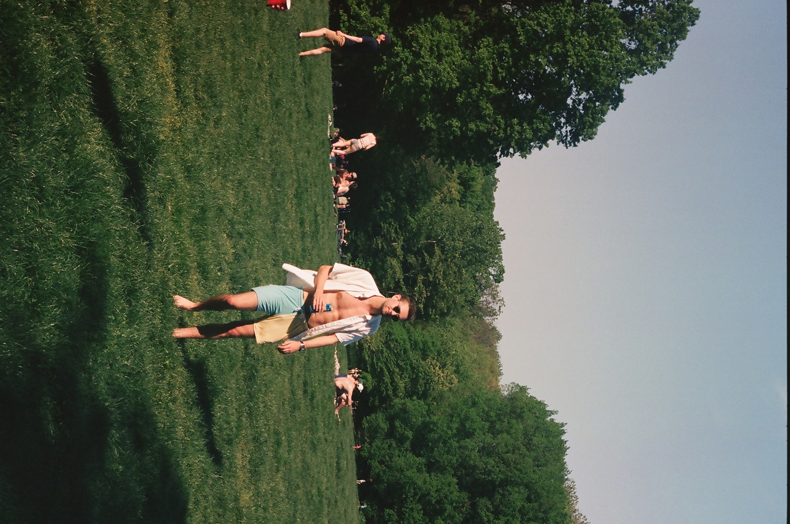 a group of people laying on top of a lush green field