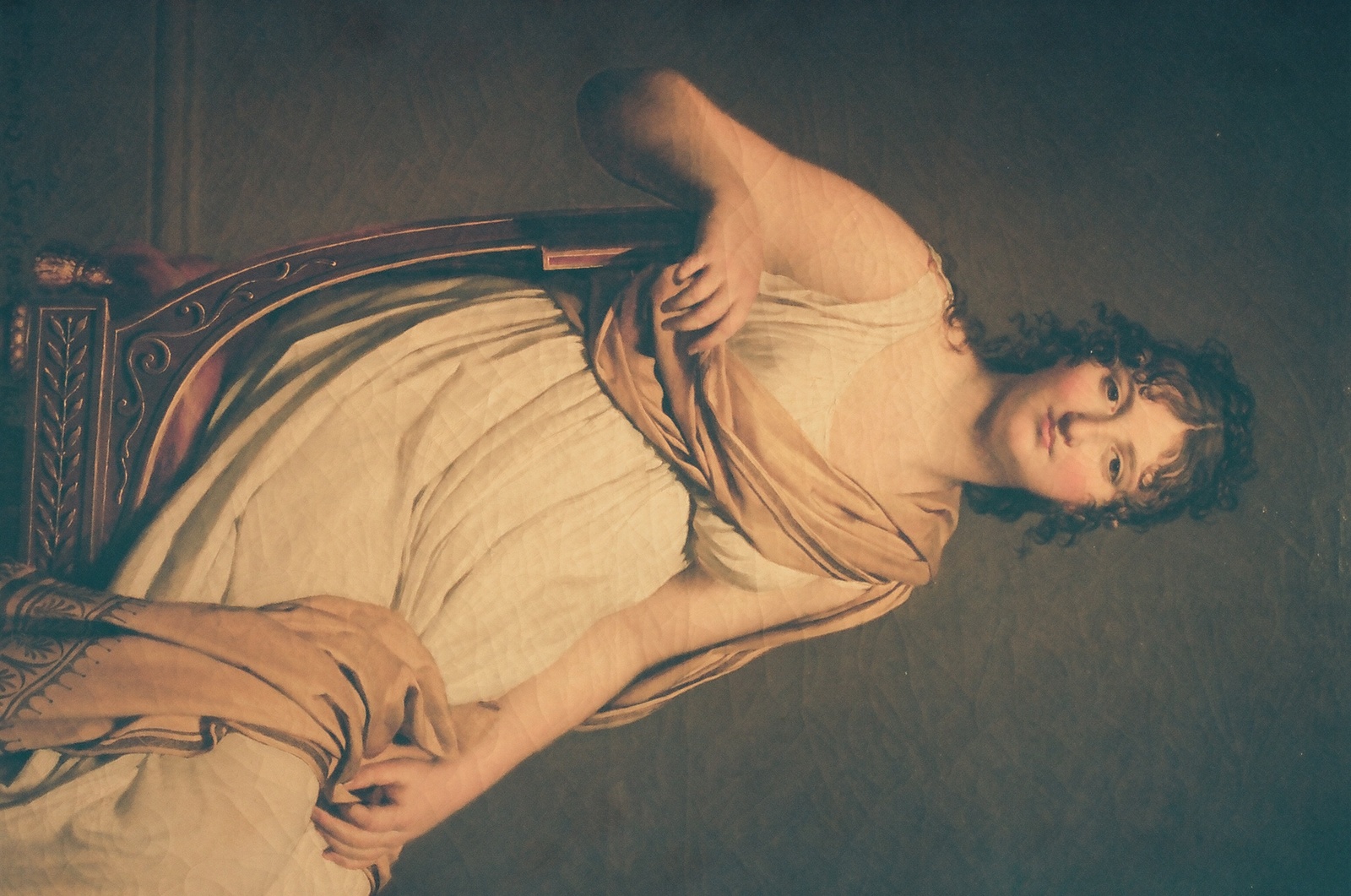 a man laying on top of a wooden chair