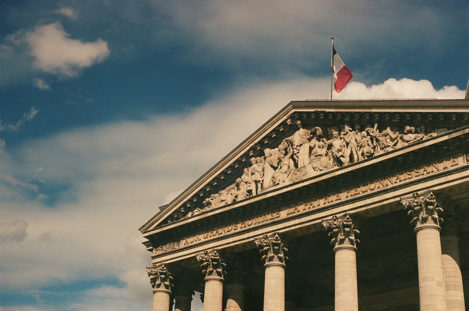 a very tall building with columns and a flag on top