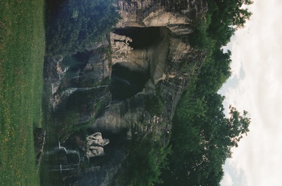 an aerial view of a grassy area with a rock formation