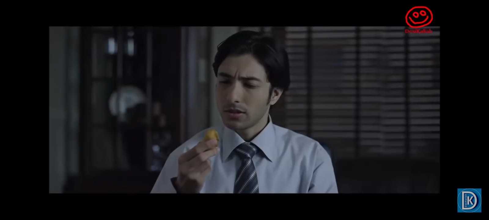 a man in a shirt and tie holding a piece of food