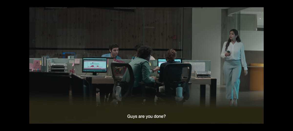 a group of people sitting at a desk with computers