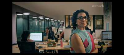 a woman standing in front of a desk in an office