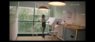 a woman standing in front of a desk in a room