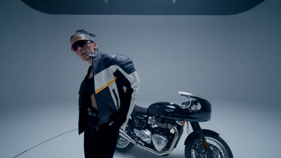 a man standing next to a motorcycle in a studio