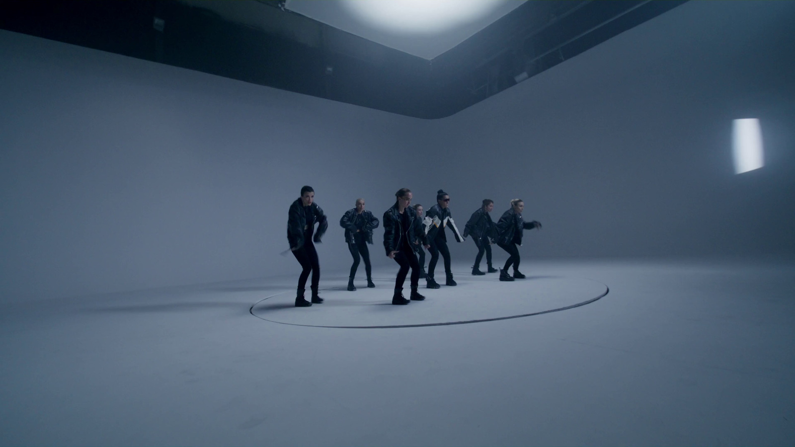 a group of people standing in a white room