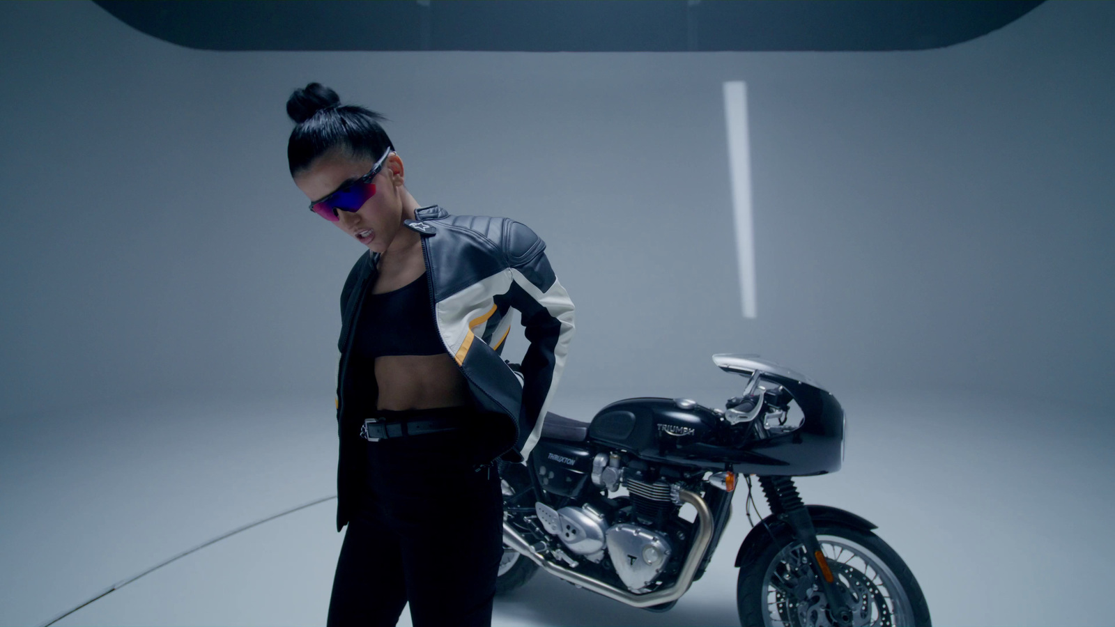 a woman standing next to a motorcycle in a studio