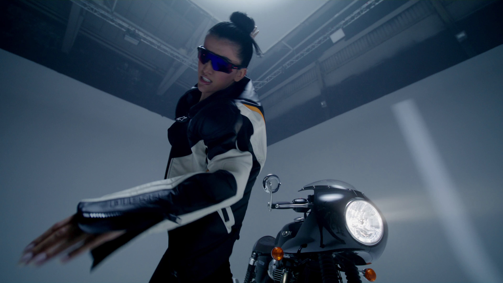 a woman standing next to a black motorcycle