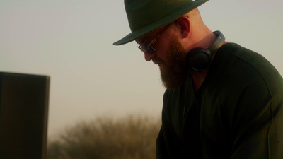 a man with a beard wearing a green hat