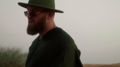 a man with a beard wearing a green hat