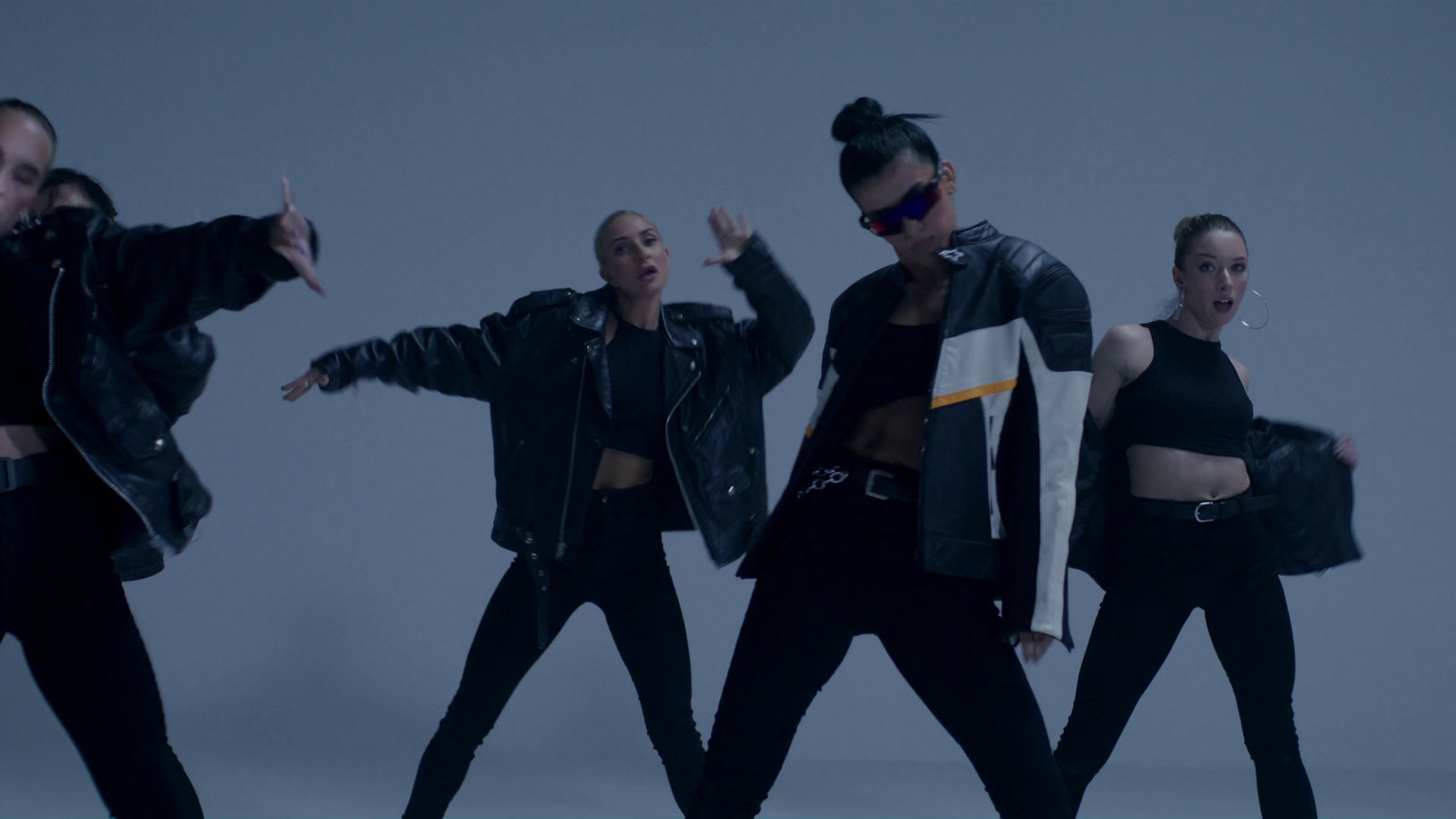 a group of women in black outfits dancing