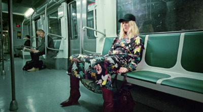 a woman sitting on a train seat next to a man