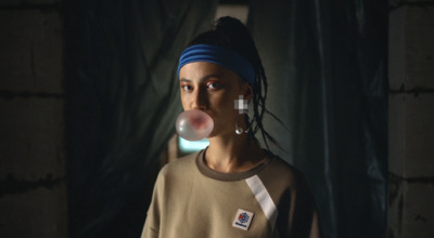 a woman with a blue headband blowing a bubble