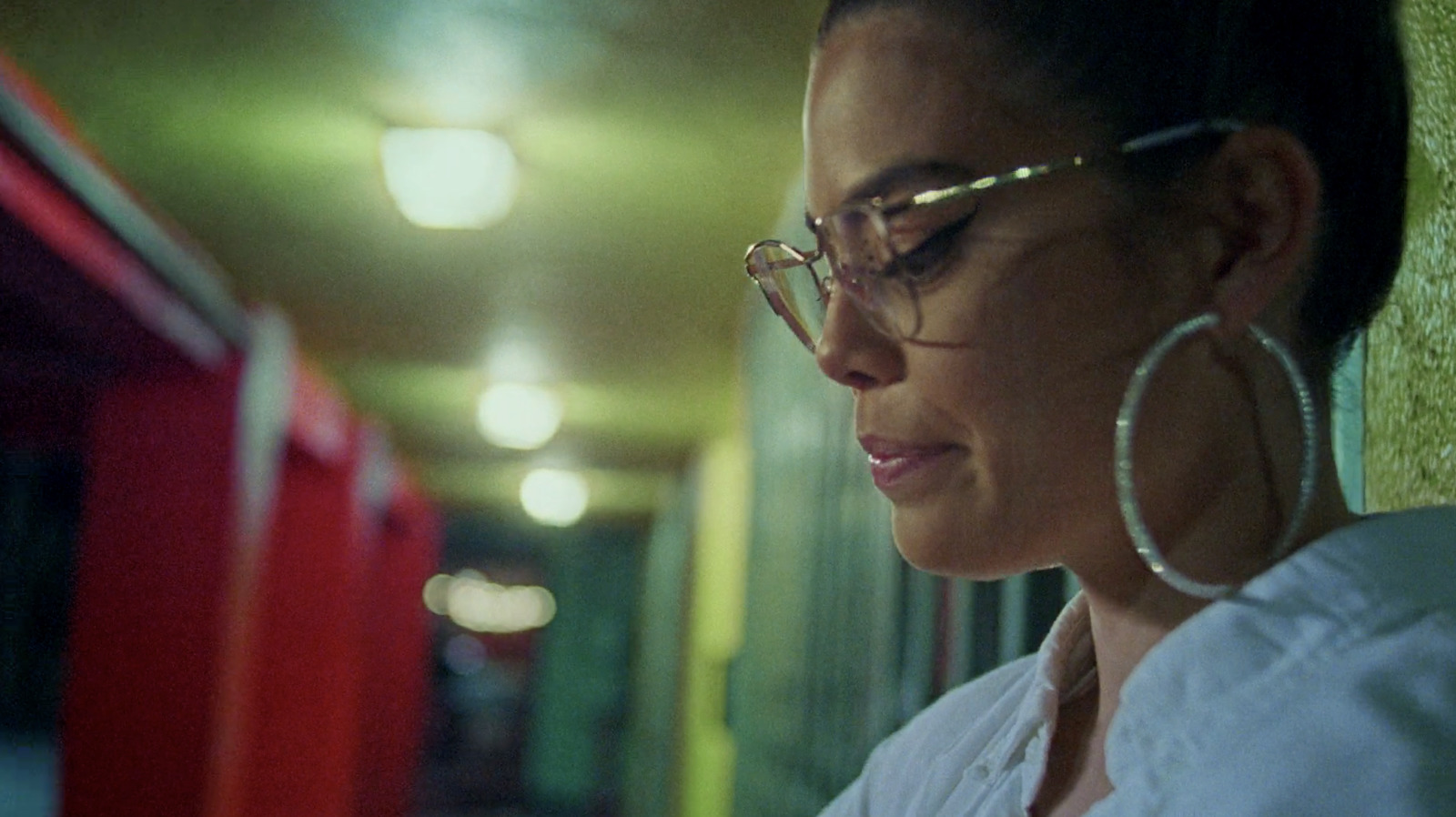 a woman in glasses looking at her cell phone