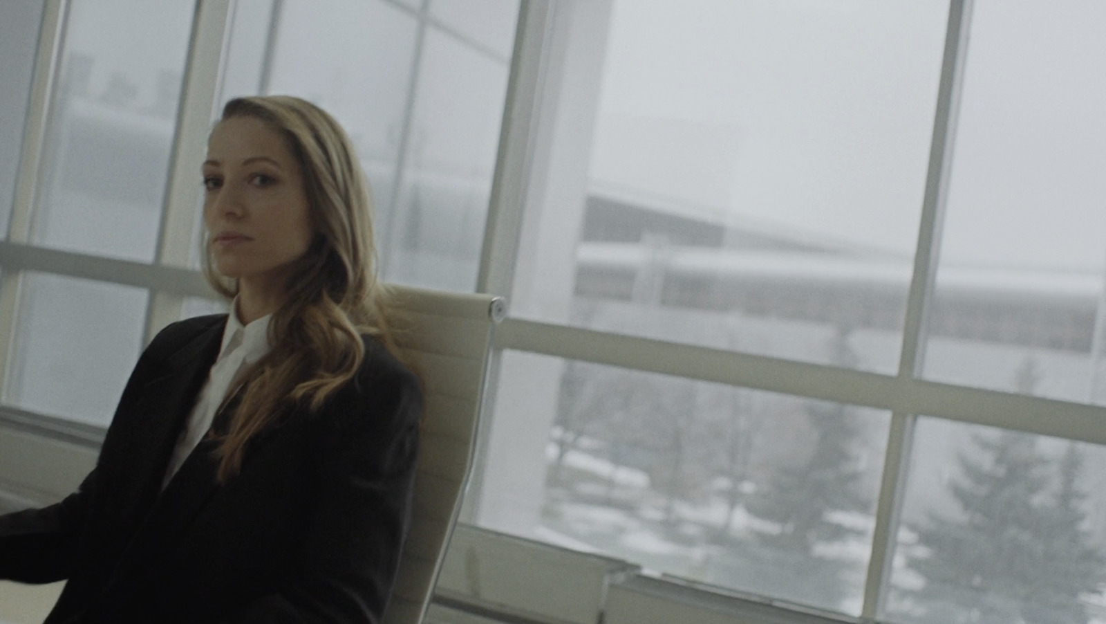 a woman sitting in a chair in front of a window