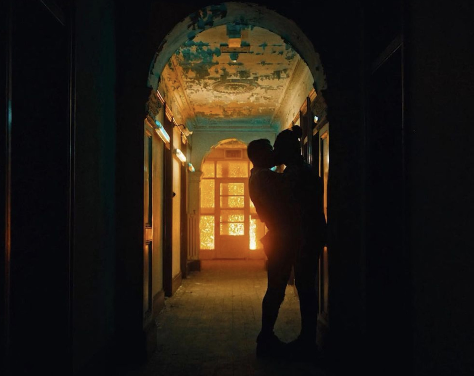 a man and a woman standing in a dark hallway