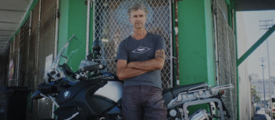 a man standing next to a parked motorcycle