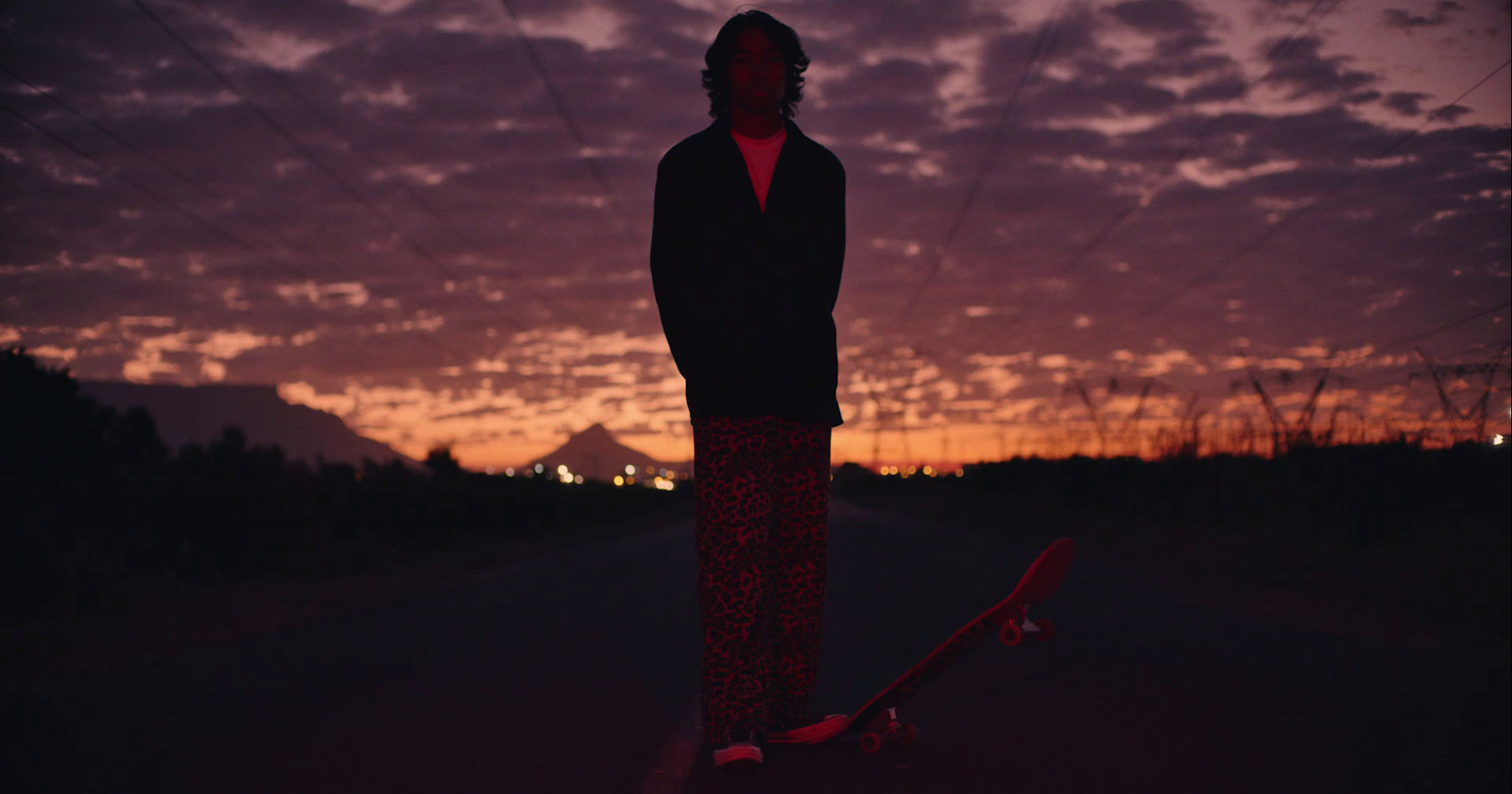 a person standing on a skateboard in the middle of the road