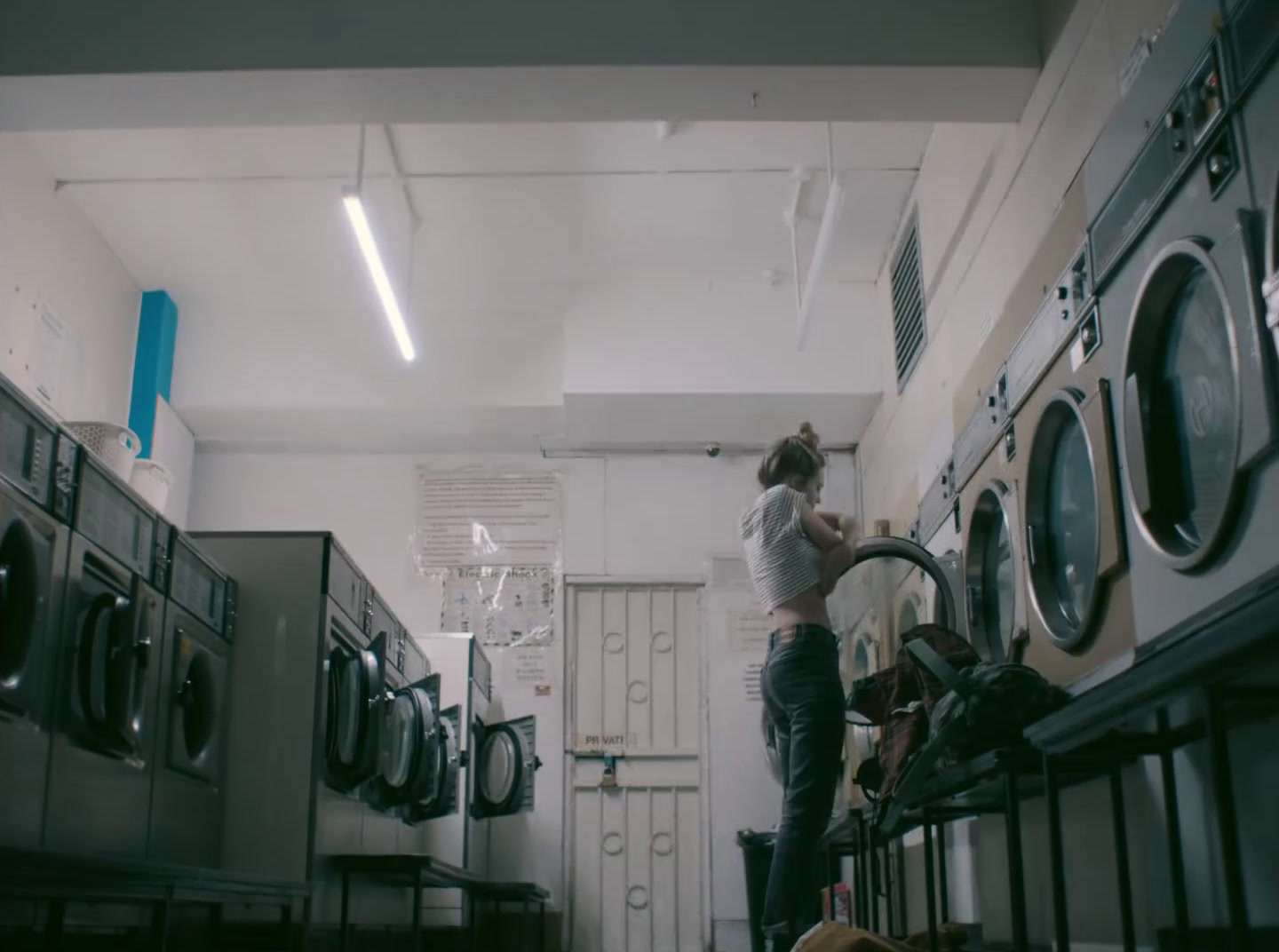 a woman standing on top of a stack of washers