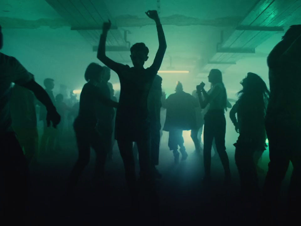 a group of people dancing in a dark room